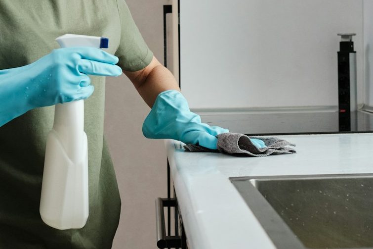 Deep Cleaning Services in Milton Keynes A person thoroughly cleans a kitchen counter, a deep cleaning service by Kals Kleans in Milton Keynes.
